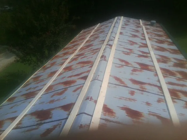 Rusted metal roof panels with new wood purlins before replacement — Storm Damage Roof Repair in Sneads Ferry by Roofing Brothers