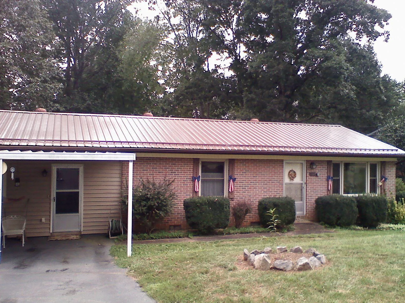 Bronze metal roof and carport on a brick ranch home — Roof Repair work by our crew in Sneads Ferry