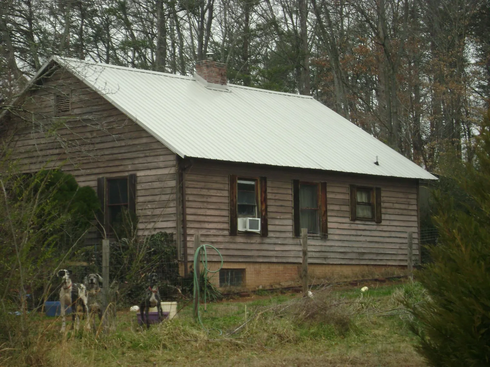 White metal roof on an old wood sided farmhouse, from a Metal Roof Installation job in Sneads Ferry